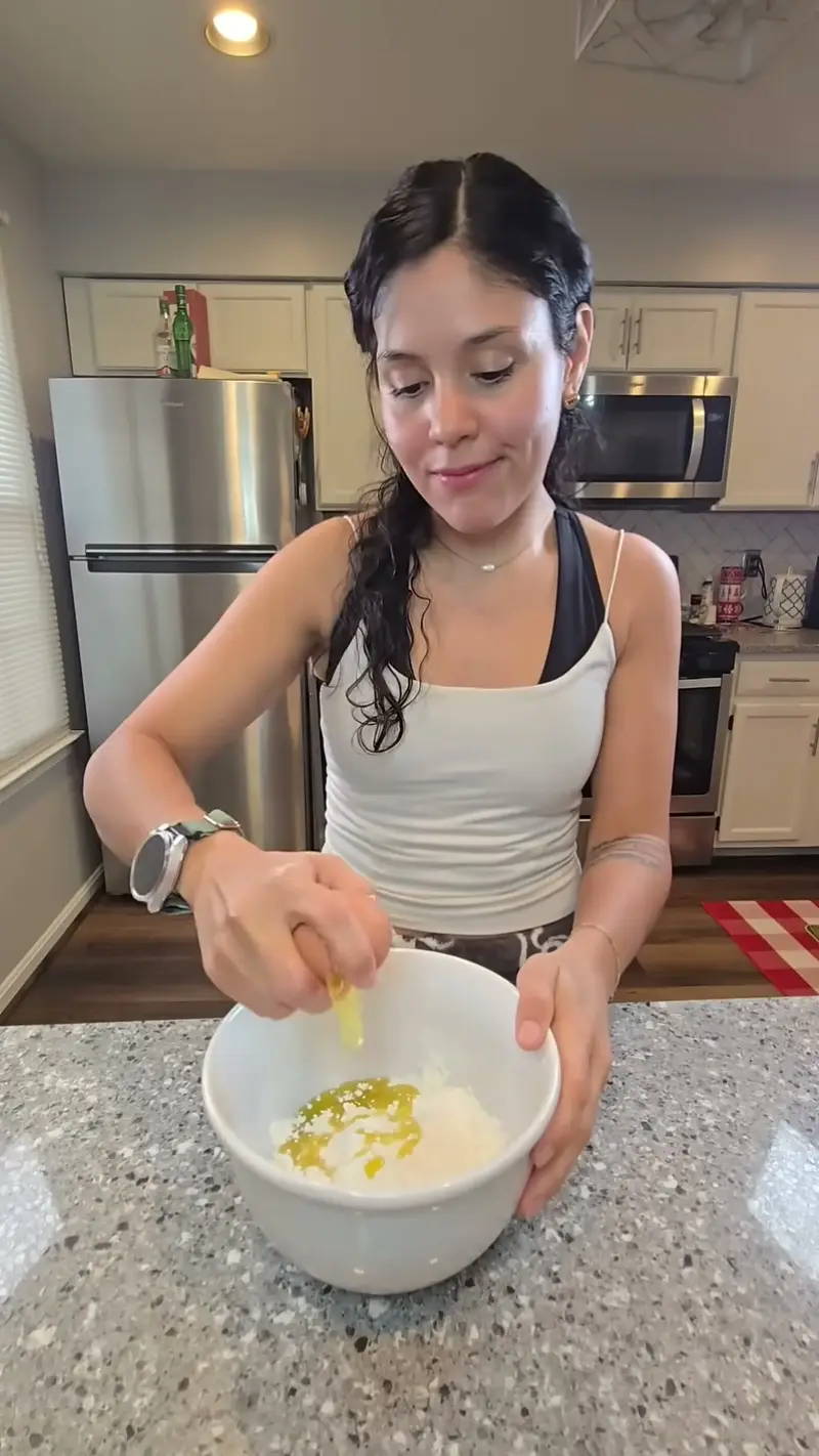 Crystal whisking eggs in a white bowl at the counter