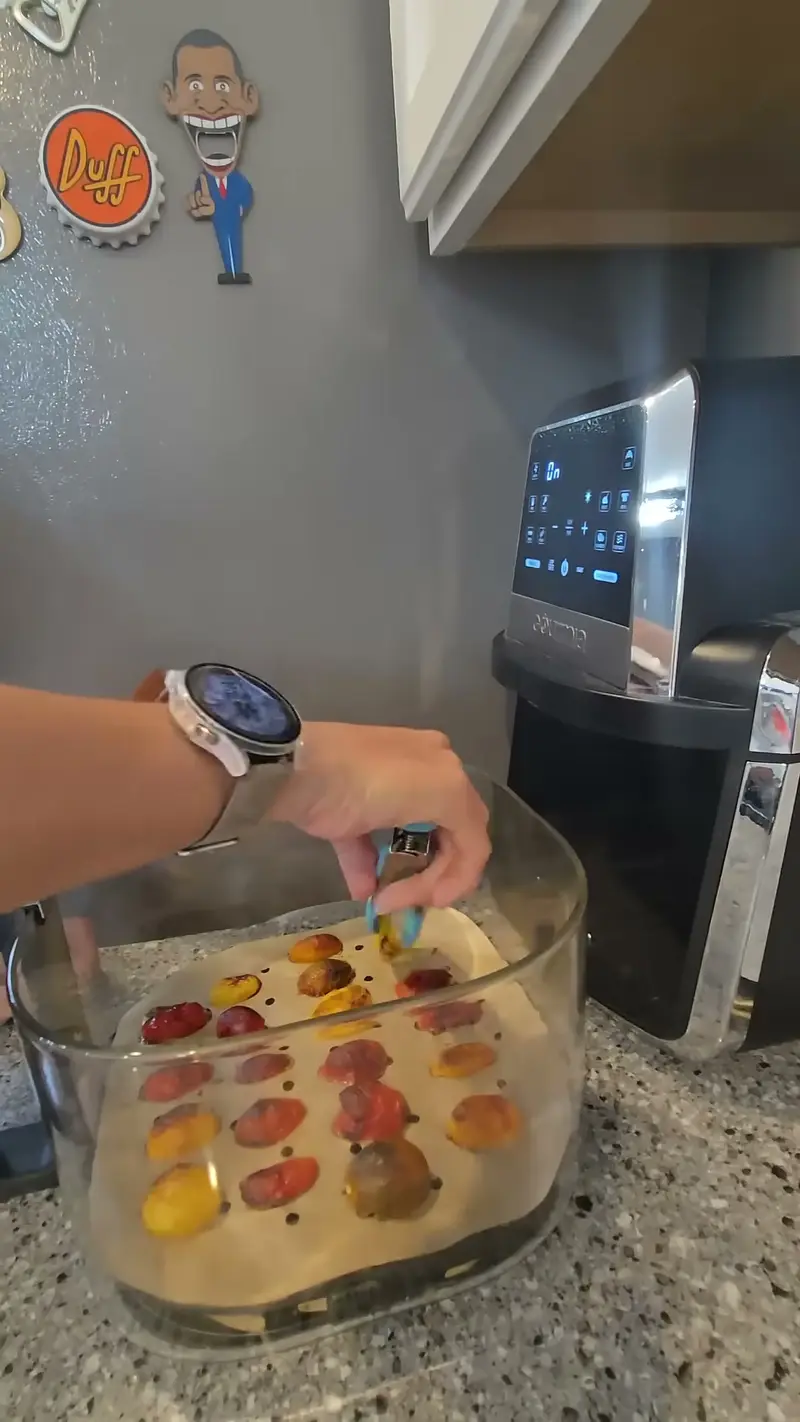 Crystal setting a glass dish of cherry tomatoes into the air fryer
