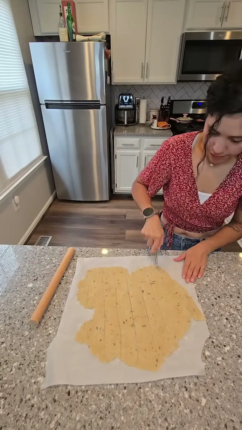Crystal scoring the rolled dough into squares with a knife