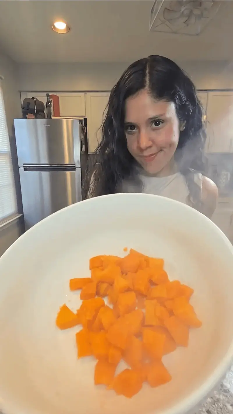 Crystal holding a plate of steamed sweet potato cubes